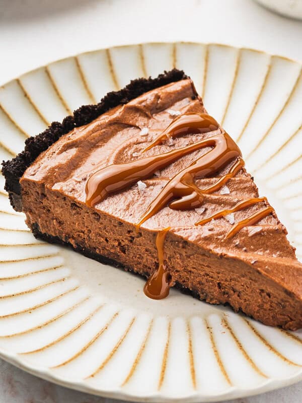 slice of chocolate mousse pie drizzled with caramel on ornate plate