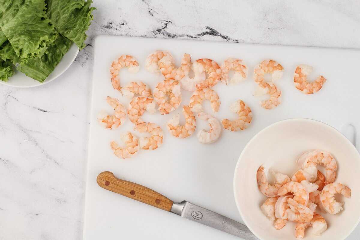 Cutting the shrimp on a white cutting board.
