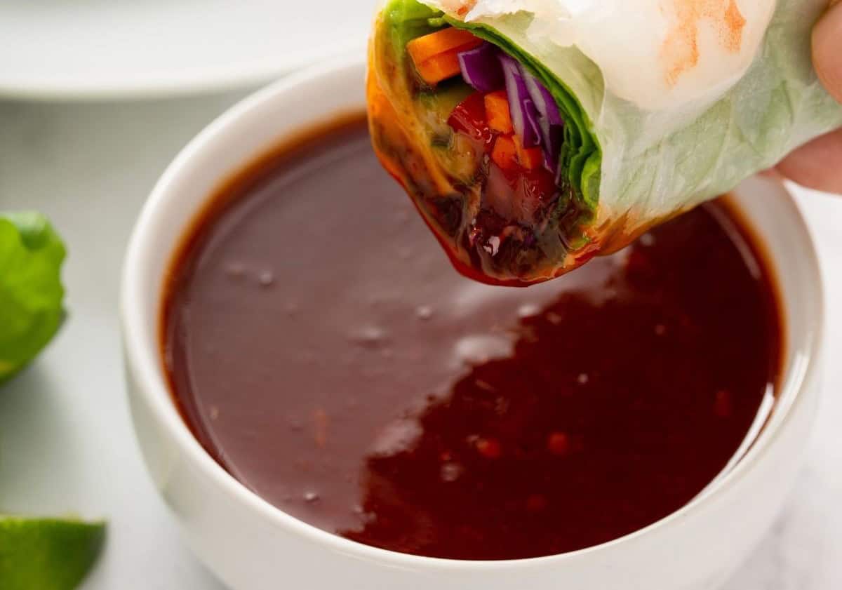Dipping the spring roll in dipping sauce.