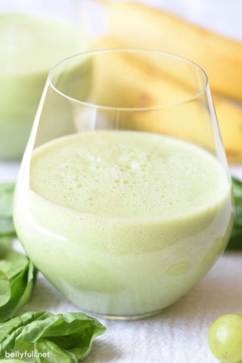 glass filled halfway with green smoothie