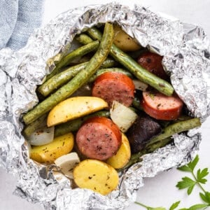 close up cooked kielbasa and vegetable foil packet dinner