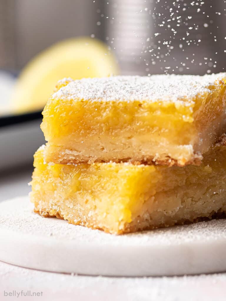 two lemon bars stacked with powdered sugar