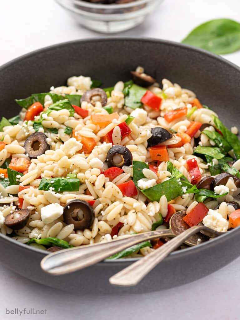 pasta salad with spinach, red bell pepper, and feta cheese in bowl