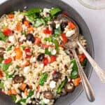 overhead bowl of Mediterranean Orzo Salad with serving spoons