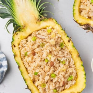 coconut rice piled inside fresh hollowed out pineapple half with spoon