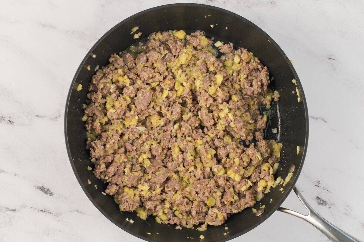 Saute pan with sausage and zucchini.