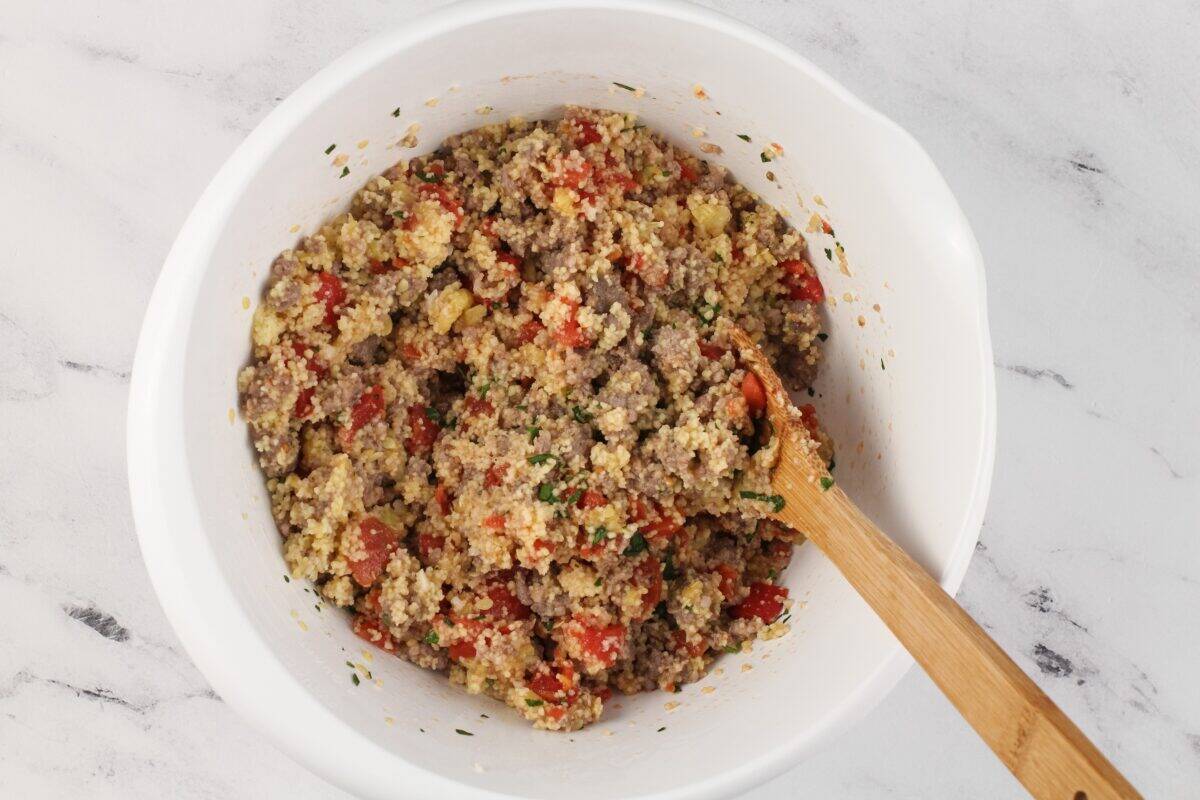 Stuffed zucchini filling in a white bowl.