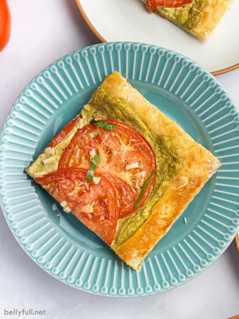 blue plate with square slice of tomato puff pastry tart