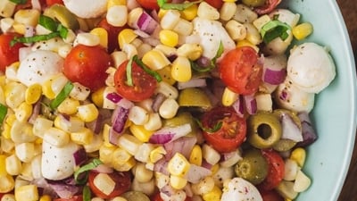 close up overhead caprese corn salad in serving bowl