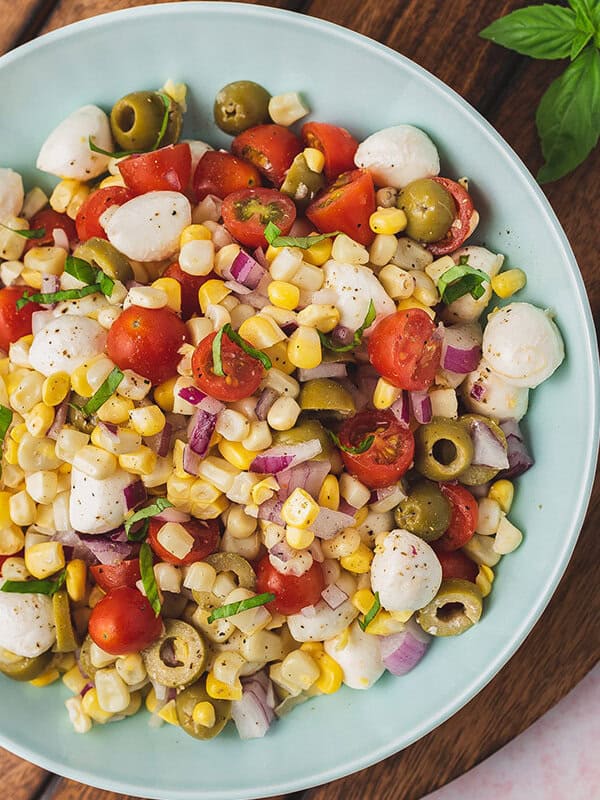 close up overhead caprese corn salad in serving bowl