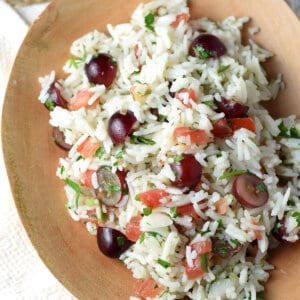 overhead cold rice salad with grapes in wood serving bowl