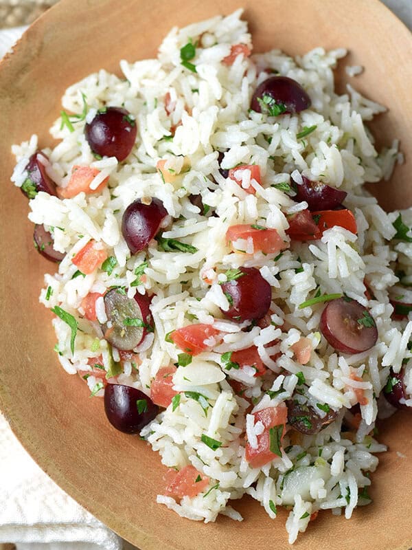 overhead cold rice salad with grapes in wood serving bowl