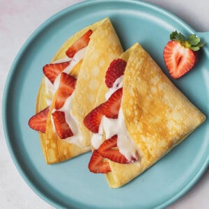 overhead crepes on plate with cream filling and sliced strawberries