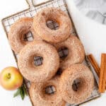 Baked apple cider donuts dipped in cinnamon sugar on a wire rack