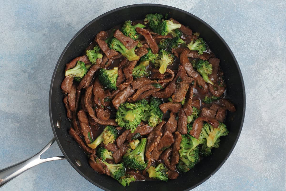 Beef and broccoli in a black skillet.