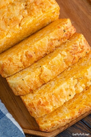 A loaf of cheese bread with four pieces sliced