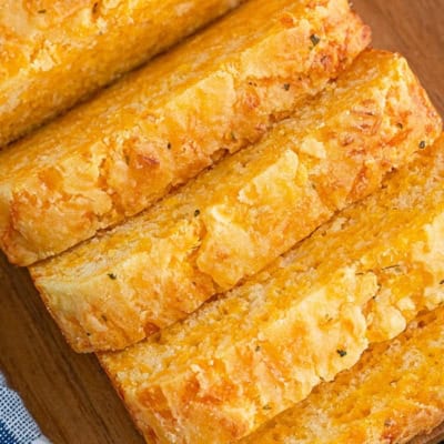 A loaf of cheese bread with four pieces sliced