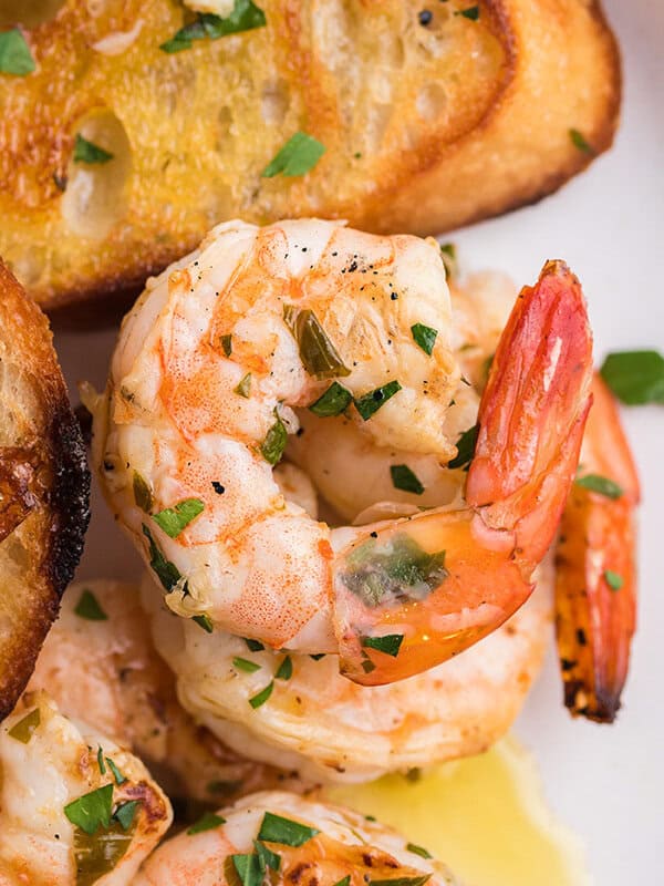 close up grilled shrimp with butter and parsley