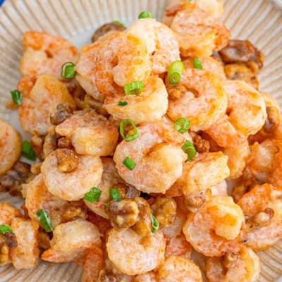 A plate of honey walnut shrimp topped with scallions