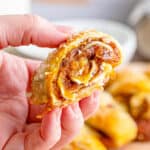 A hand holding a piece of pumpkin pull-apart roll