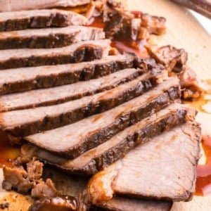 slow cooker beef brisket sliced thin on cutting board