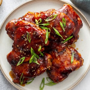 stack of baked Teriyaki Chicken thighs on late garnished with chopped scallions