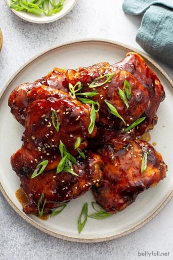 stack of baked Teriyaki Chicken thighs on late garnished with chopped scallions