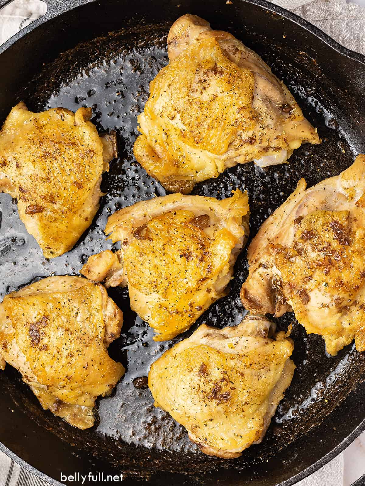 overhead view of apple cider vinegar chicken thighs in a cast iron skillet