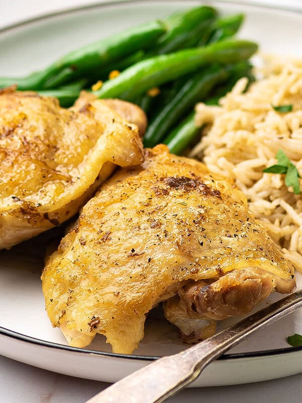 Crispy apple cider chicken on a plate, with a form in front