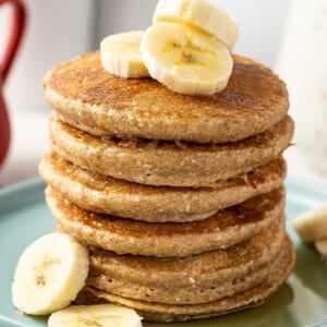 stack of 6 banana oatmeal pancakes with banana slices
