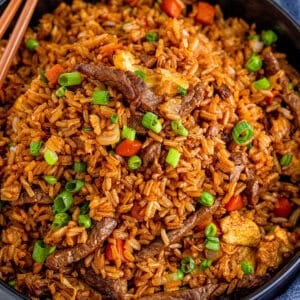 beef fried rice in black serving bowl with chopsticks