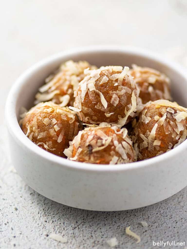 coconut flake coated protein balls in a white bowl