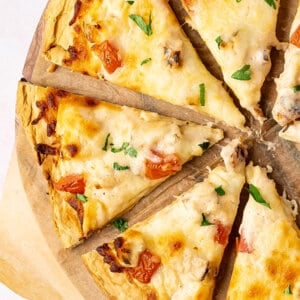 close up sliced chicken alfredo pizza