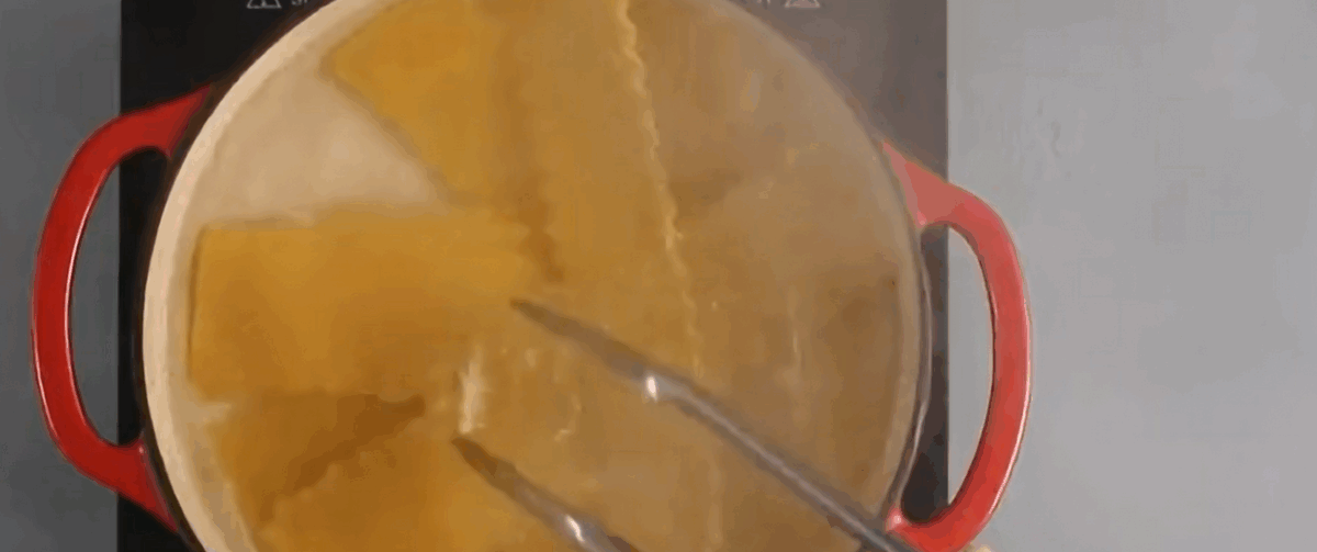 Cooking lasagna noodles in a red pot. 