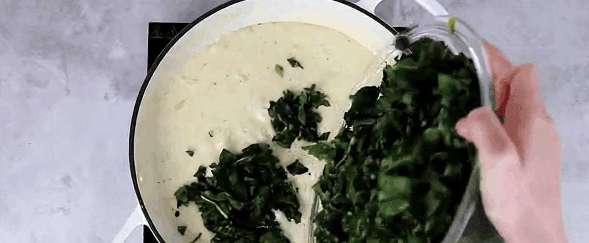 Adding spinach to the pot.