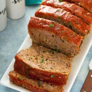 sliced glazed meatloaf on white serving plate