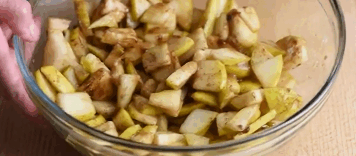 Filling ingredients for pear crisp in a glass bowl. 