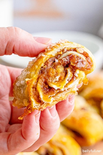 A hand holding a piece of pumpkin pull-apart roll