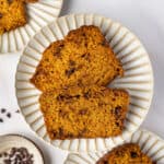 Overhead view of two slices of pumpkin chocolate chip bread on a white plate