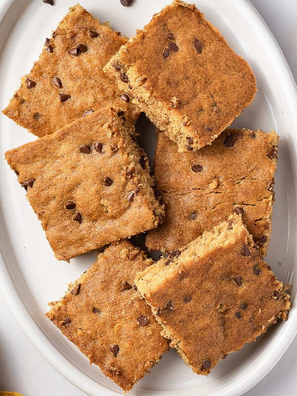 cut banana cake squares overlapping on white serving plate