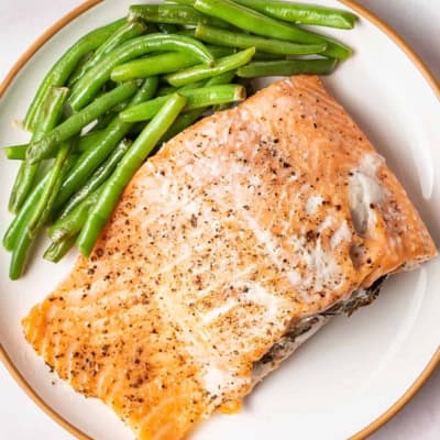 crab stuffed salmon fillet on plate with green beans