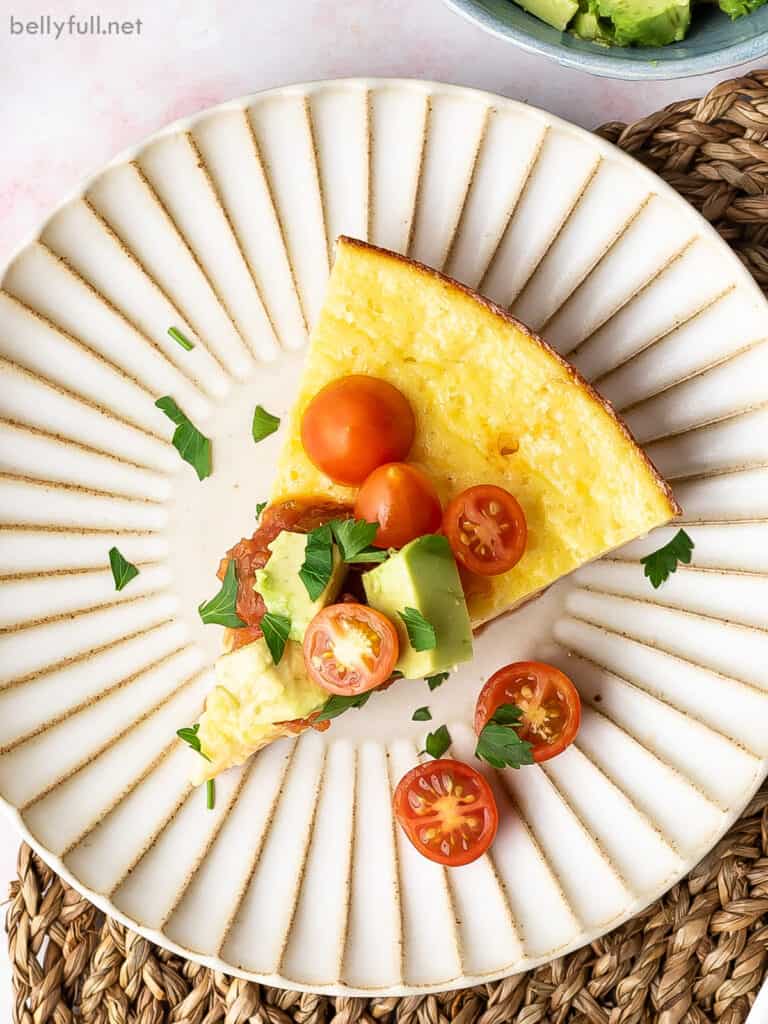 slice of thick egg omelet on plate with cherry tomatoes