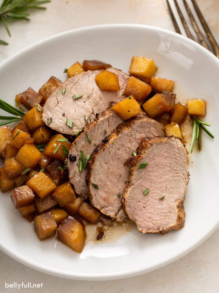 sliced roasted pork tenderloin with sauteed apples on plate