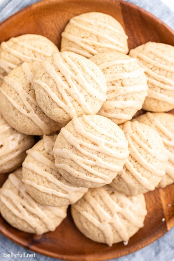 overhead pile of eggnog cookies with icing on wooden plate