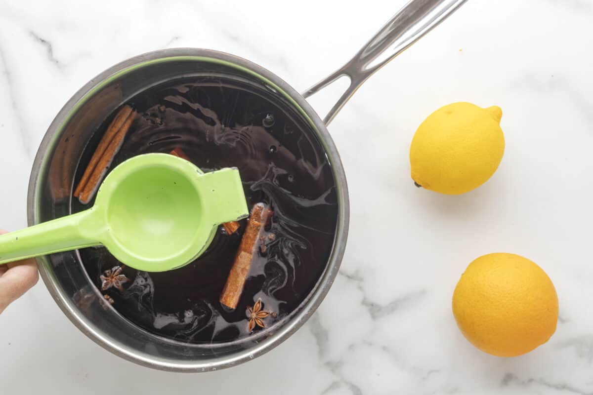 Squeezing lemon juice into the wine mixture.