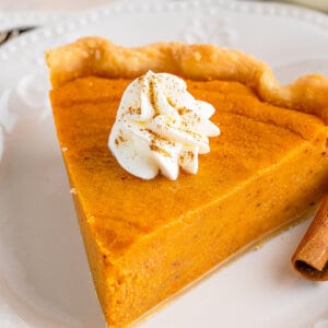 A slice of homemade sweet potato pie with a dollop of whipped cream