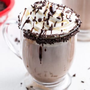 A dirty snowman cocktail topped with whipped cream and chocolate syrup