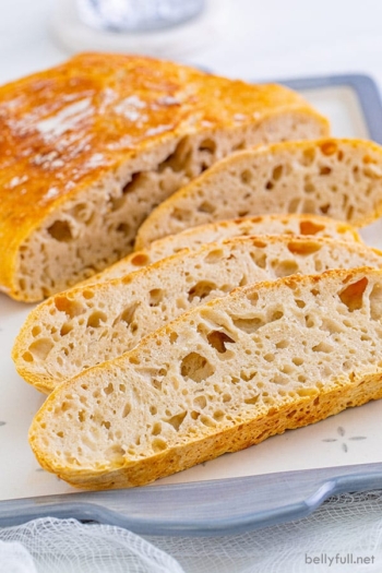 A loaf of no knead bread with 3 slices