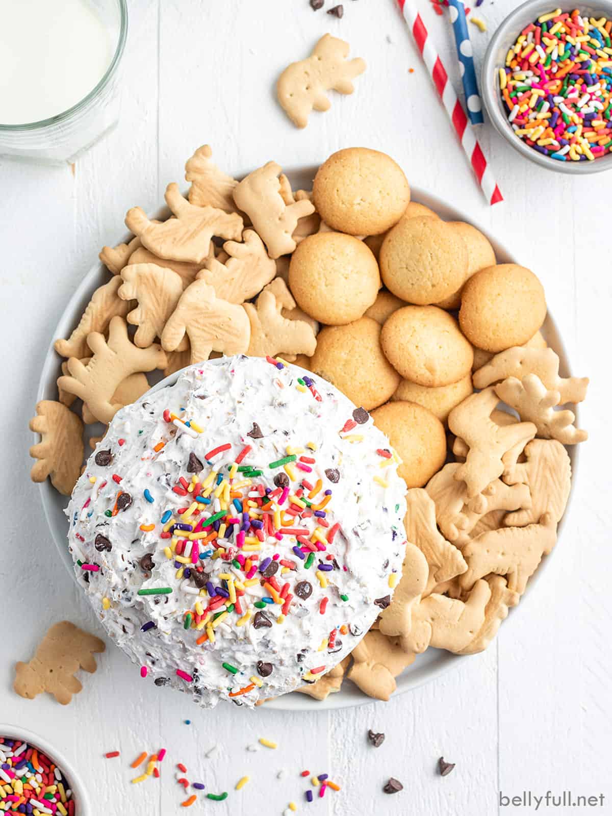 Overhead view of funfetti dessert dip on a platter with animal crackers and vanilla wafers