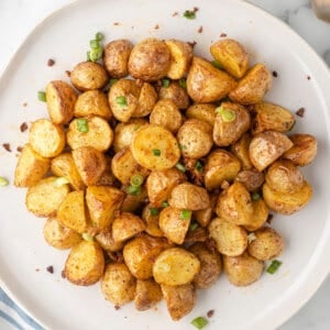 overhead pile of oven roasted potatoes on white plate